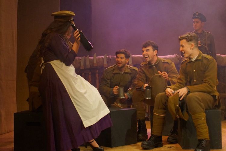 Actors in military uniform and one dressed as a maid on stage